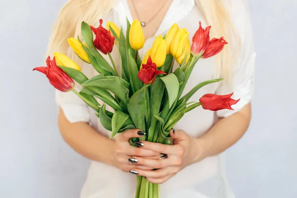 Yellow and pink tulips girl holding hands on white background — Stock Photo, Image