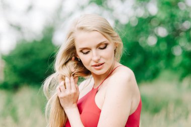 Kırmızı elbiseli bir yeşil bir arka plan üzerinde beyaz saçlı genç kız