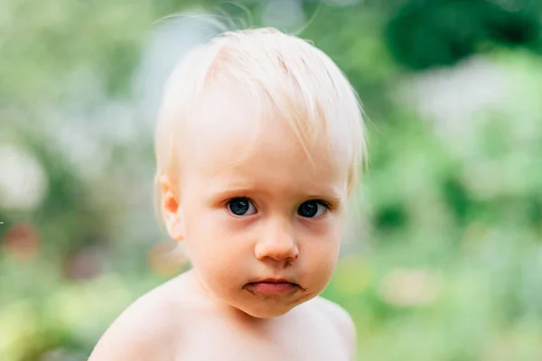 stock image a child with blue eyes is playing in the village in the summer