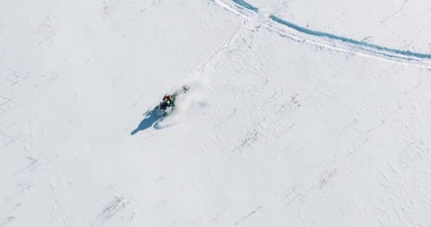 Снігохід їде на полі, вид зверху з дрона — стокове відео