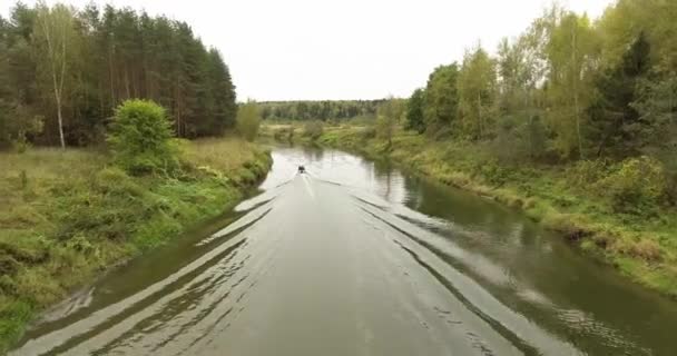 Моторная лодка вдалеке плавает по реке — стоковое видео