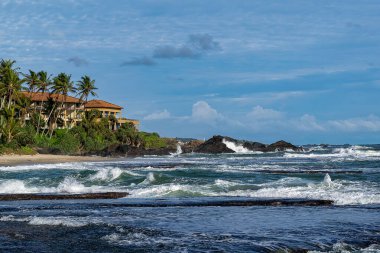 Sri Lanka, - Sept 2015:  Waves crashing onto the beach at Galle, overlooked by luxury property
