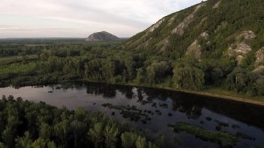 Bir yaz günü Shikhan Kushtau adlı kireçtaşından oluşan antik deniz resifinden geriye kalanlar. Ufukta Yuraktau Dağı görünüyor. Bashkiria 'nın ana nehri, Belaya. Hava görünümü.