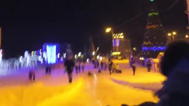 Çocuklar kasaba meydanında buz kaydırağına biniyorlar..