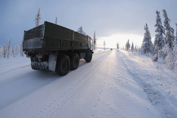 Uzak Kuzey. Kamyon kış yolunda ilerliyor..