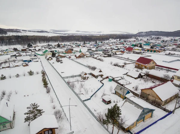 Southern Urals. Bashkir village of Makarovo in the mountains in winter. Aerial view.