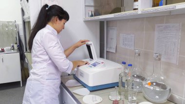 Bakteriyoloji laboratuvarı. Biyokimyasal analiz. Laboratuvar asistanı spektrofotometrik analiz yapar..