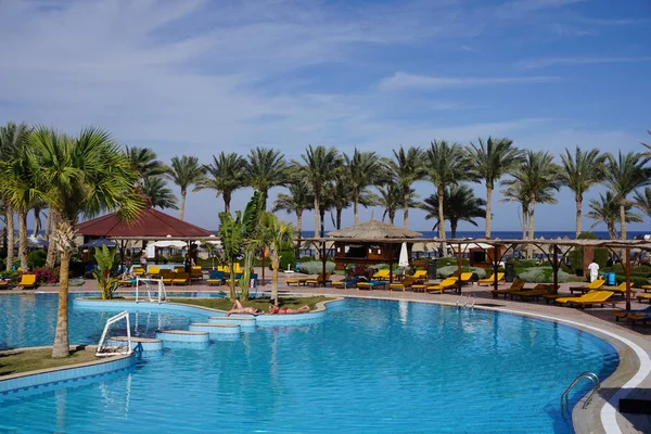 Superbe parasol de luxe et chaise autour de la piscine extérieure à l'hôtel et station balnéaire avec cocotier sur ciel bleu - Boostez la couleur Traitement — Photo