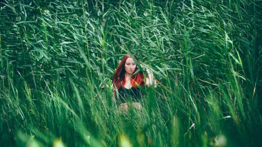 Tatilde. Gölde bikinili, şehvetli bir kız. Kızıl saçlı kadın bu şekilde rahatlarken eğleniyor. Yaz zamanı..