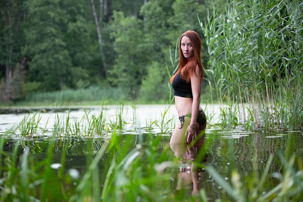 Vacaciones. Chica sensual en bikini en agua en el lago. Mujer pelirroja divirtiéndose relajándose. Verano. . — Foto de Stock