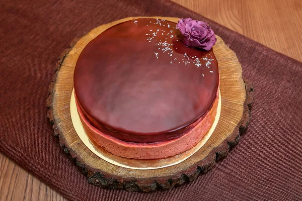 Okrągłe ciasto czekoladowe z wystrojem na drewnianym stole — Zdjęcie stockowe