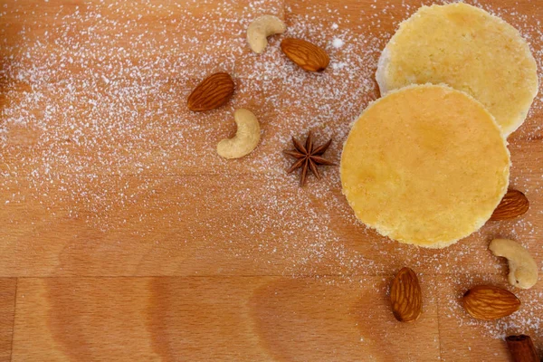 cakes with nuts, anise, cinnamon, sugar powder lie on wooden board.