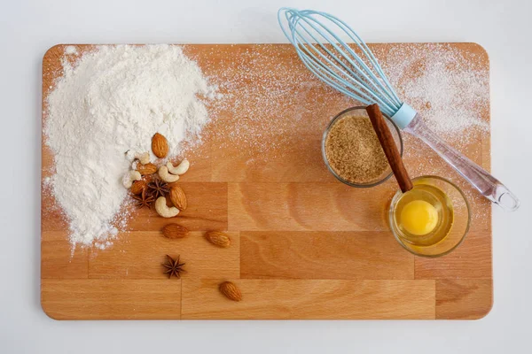 Baking cake in kitchen - dough recipe ingredients on wooden table.