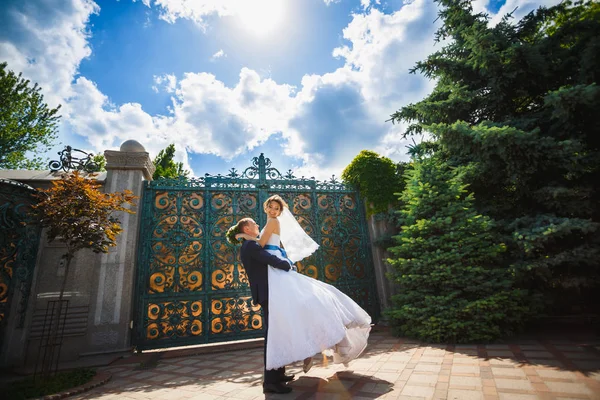 Bröllopsparet kramas och virvel vid grinden — Stockfoto