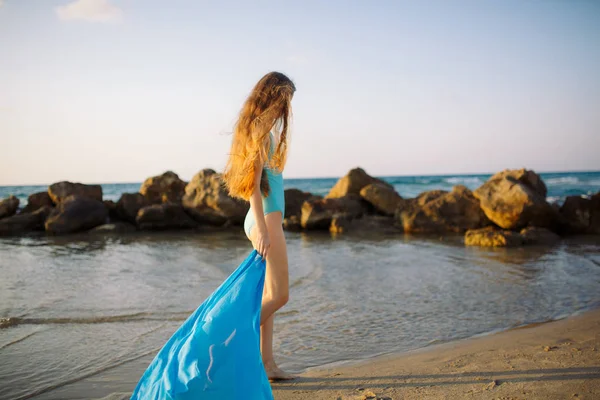 Девушка в купальнике прогуливается по пляжу на побережье — стоковое фото