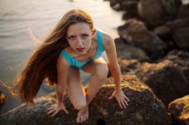 Rüzgar saçlı tatilde kameraya gülümseyen kız.