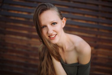 Sevimli kadın ahşap arka plan üzerinde poz mutluluk ifade.