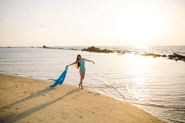 Девушка стоит на пляже и разводит руки в стороны — стоковое фото