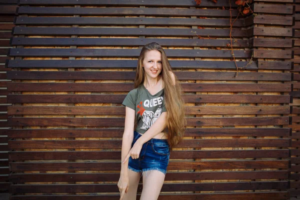 Passionate sweet young girl dancing on wooden wall background copyspace — Stock Photo, Image