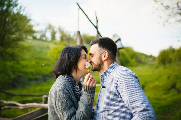 Pareja besándose en campo prado en la primavera al atardecer — Foto de Stock