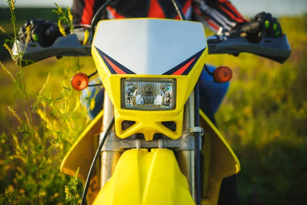 Желтый мотоцикл фары в поле цветов, вид спереди — стоковое фото