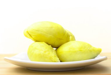 Beyaz arka plan ile ahşap zemin üzerinde beyaz plaka sarı durian meyve