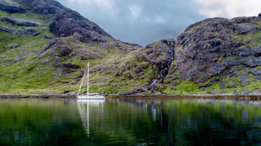 Güzel bir şelale içinde belgili tanımlık geçmiş ve loch, İskoçya, Birleşik Krallık'taki bağlantılı bir yat ile Isle of Skye, loch coruisk görünümünü