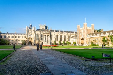 Cambridge, Cambridgeshire / Birleşik Krallık - 17 Haziran 2016: Parlak bir yaz günü, Cambridge, Cambridgeshire, Birleşik Krallık 'ta ünlü Trinity kolejinin önünde yürüyen öğrenciler