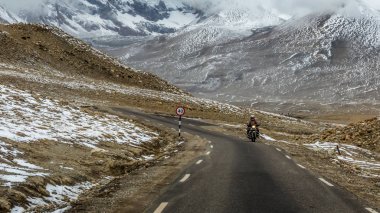 Lachen, Sikkim, Hindistan - 30 Nisan 2018: 17.000 feet yükseklikte Gurudongmar Gölü yakınlarındaki Kuzey Sikkim 'in Himalaya yollarından geçen bir motosiklet, Lachen, Sikkim, Hindistan