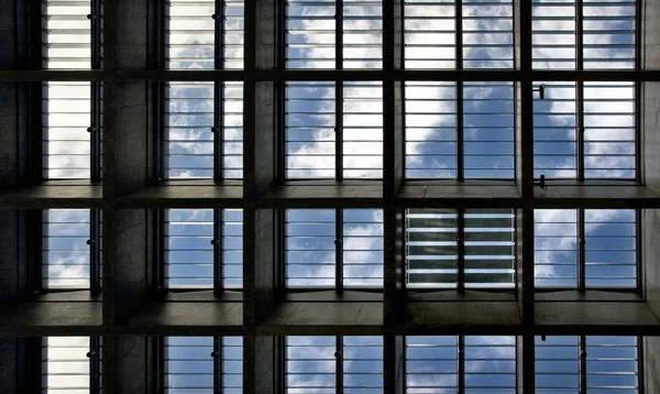 Op zoek naar de blauwe hemel met wolken door dakvensters — Stockfoto