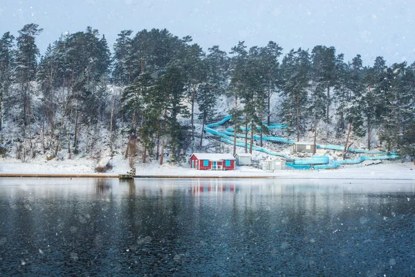 Empty waterslide with red beach hut near frozen lake — Stock Image Empty waterslide with red beach hut near frozen lake Stock Picture