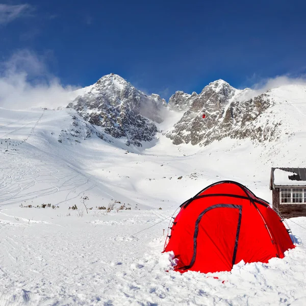 Ljusa röda klättring tält på snö med Lomnicky Stit peak — Stockfoto