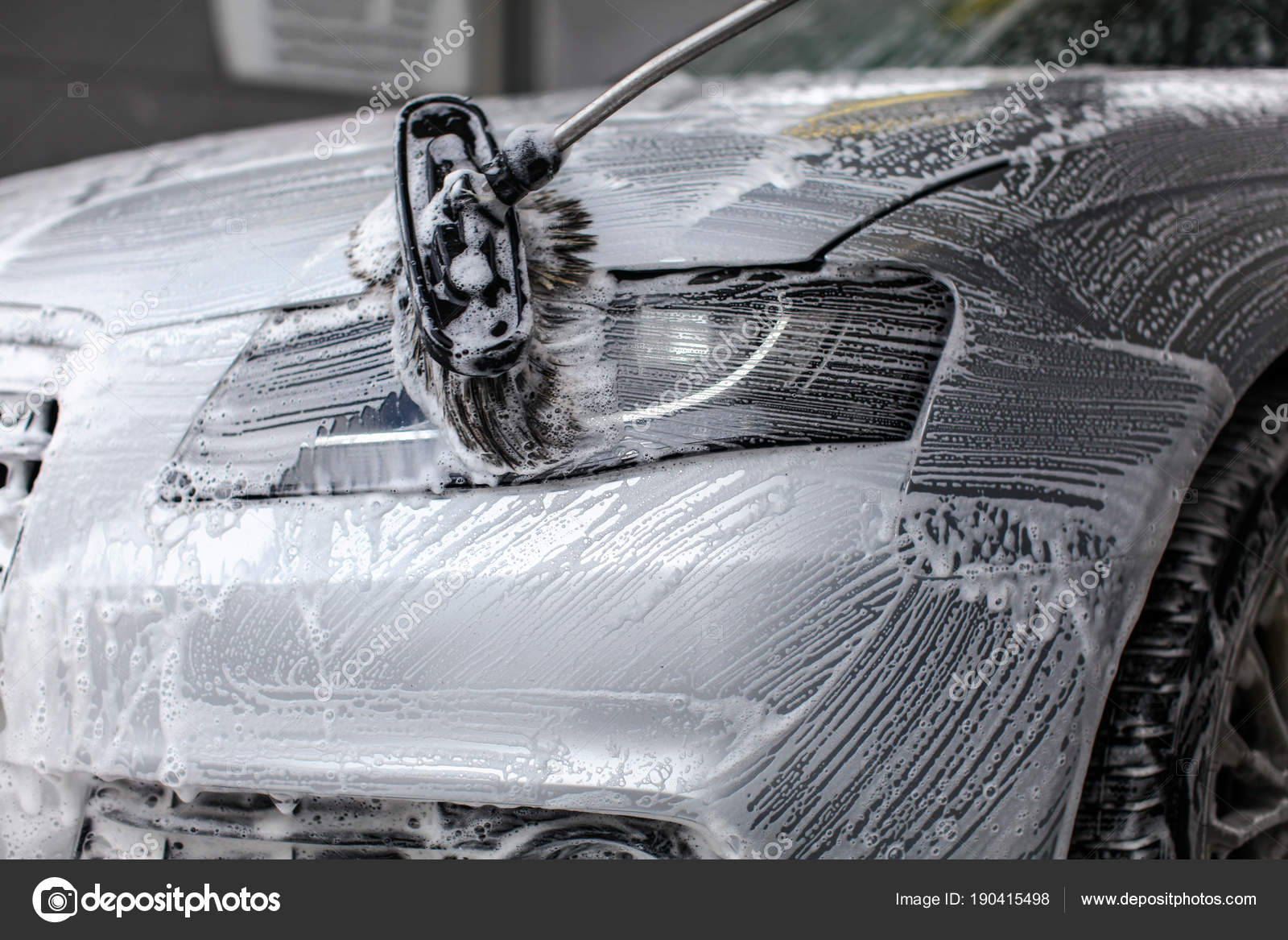 Detalle de la luz delantera del coche que se lava con espuma de