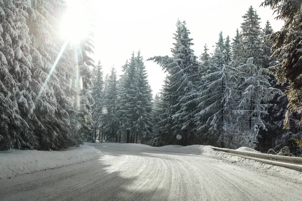 View from a car riding through snow covered winter road curve — Stock Photo, Image