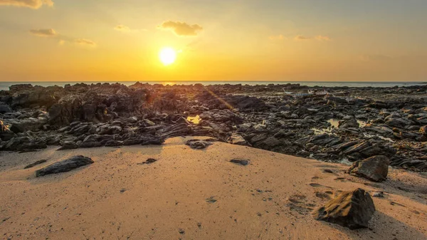 Rocks and sandy beach uncovered in low tide with boats on dry la — Stock Photo, Image