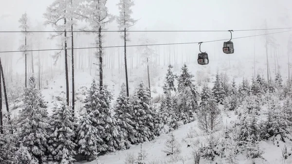 Two chairlift cabins passing each other on gray winter overcast — Stock Photo, Image