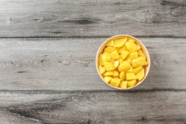 Çiğ patates bej kase küçük parçalar halinde kesip üzerinde tablo Üstten Görünüm