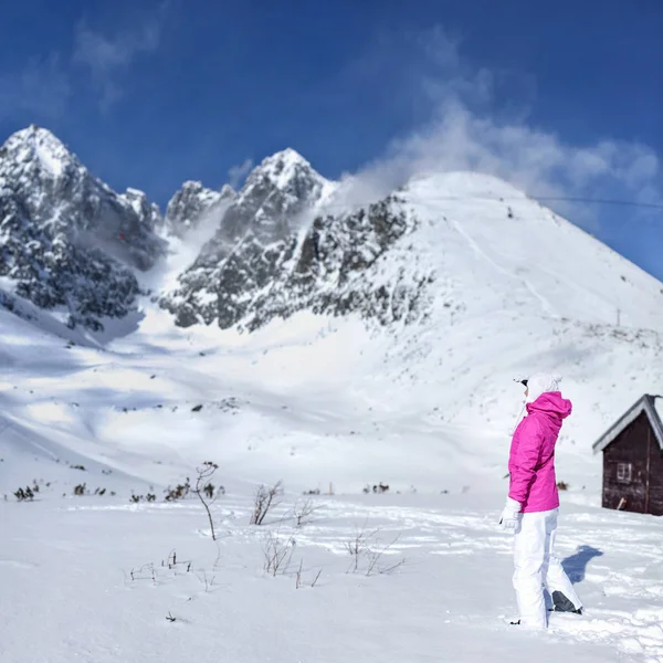 Young woman in pink ski jacket, gloves, hat looking at the top — Stock Photo, Image