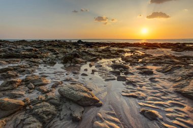 Golden sunset ışık sırasında düşük tide gösteren kum plaj