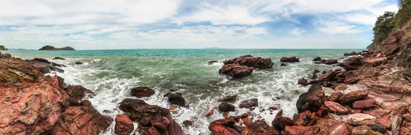 Panoramă largă de înaltă rezoluție a valurilor de mare zdrobind roci roșii cu cer albastru cu nori în fundal. Koh Lanta, Thailanda — Fotografie, imagine de stoc