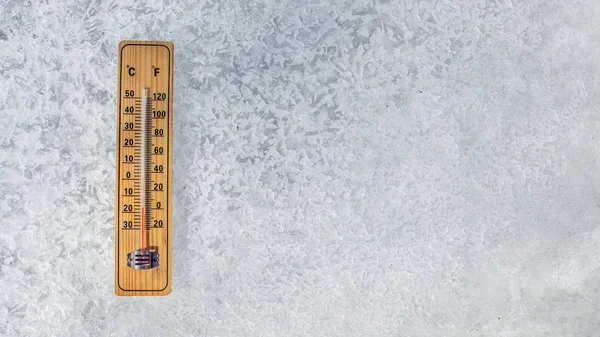 Ansicht von oben auf dem Thermometer, das auf einer Eisschicht liegt und Temperaturen von bis zu -20 Grad Celsius anzeigt. Konzept veranschaulicht extreme Kälte im Winter. — Stockfoto