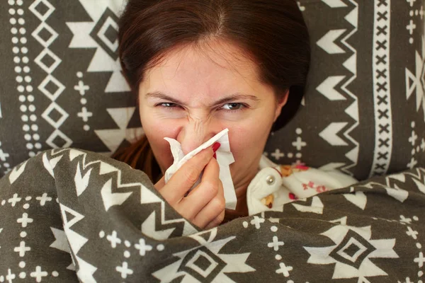 Больной молодой женщины в пижаме, лежащей в постели, покрытой одеялом , — стоковое фото