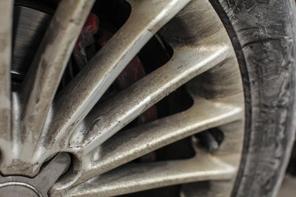 Detail stříbrné auto ráfek a pneu, velice špinavý od prachu a oleje. — Stock fotografie