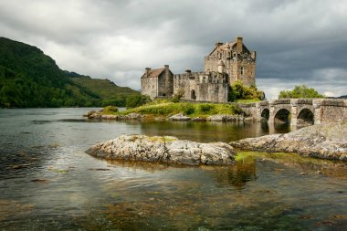 Güneş parlar bulutların üstünde Eilean Donan aracılığıyla ile taş castle