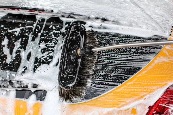 Detalle de la ventana trasera del coche amarillo oscuro lavada en carwash . —  Fotos de Stock