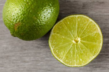 Yarım ve bütün bir parçası tablo üstten görünüm üzerinde yeşil limon kesilmiş, 