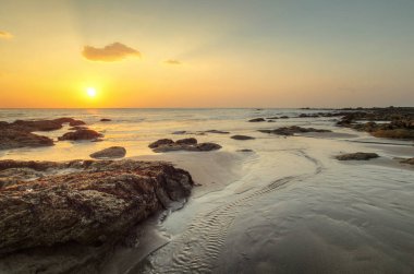 W akışı gösterilen gelgit sırasında altın günbatımı ışık Beach'de
