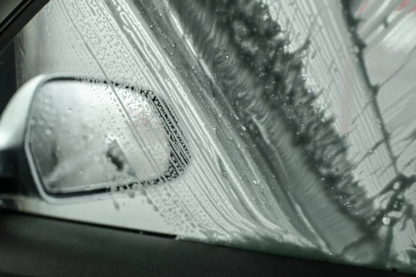 Vista desde el interior del coche al espejo lateral y la ventana que se lava i — Foto de Stock