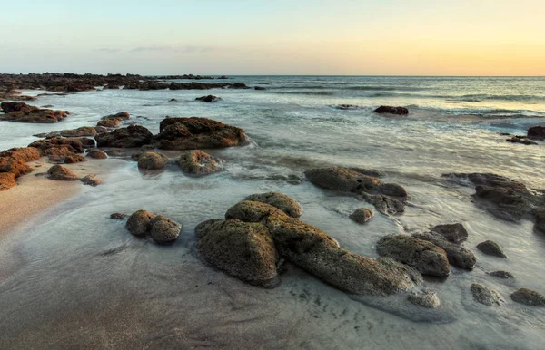 Rocky beach uncovered in low tide after evening sunset. — Stock Photo, Image