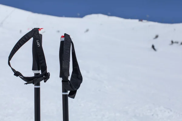 Detalle en bastones de esquí empuñadura de mano, con pista borrosa con esquiadores y —  Fotos de Stock
